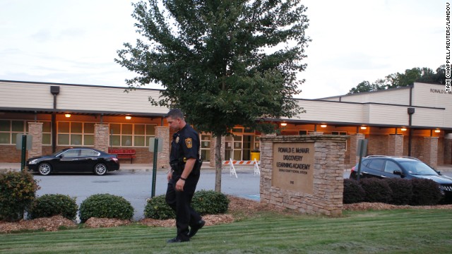 A policeman walks in front of Ronald E. McNair Discovery Learning Academy after a shooting incident in Decatur, Georgia, on Tuesday, August 20. Michael Brandon Hill, 20, opened fire at the school armed with an AK-47 "and a number of other weapons," police said. There were no reports of injuries.