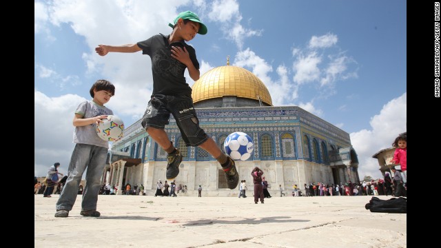 Daily life in Jerusalem: A boy plays with a soccer ball in front of the Dome of the Rock. It's one of several key religious sites, all contained within a tiny area, making anyone's first visit to the Old City unforgettable.
