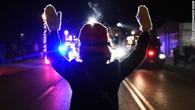 A protester holds her hands up in front of police on Tuesday, November 25. 