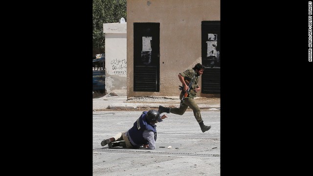 AFP reporter Sammy Ketz hits the ground as a Syrian soldier runs past during sniper fire in Maalula on September 18. Ketz and a photographer were reporting on the ancient Christian Syrian town northeast of Damascus.