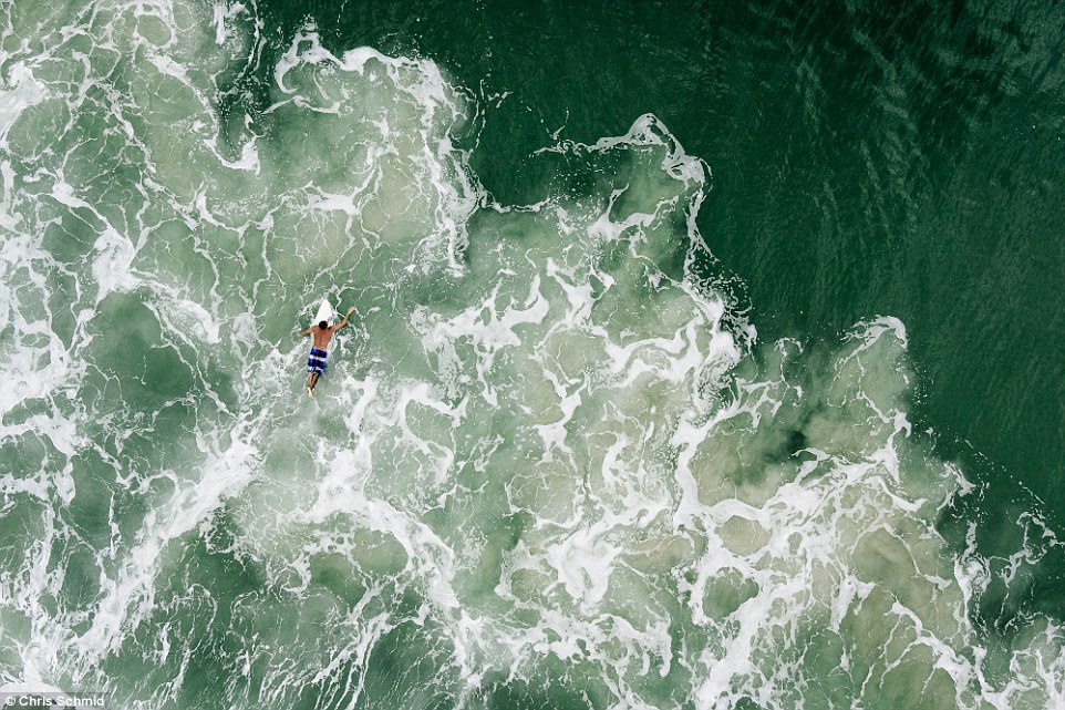 Birdview of a surfer in the famous beach of Praia Mole located in Florianopolis, Brazil. This image has been made with the help of a drone