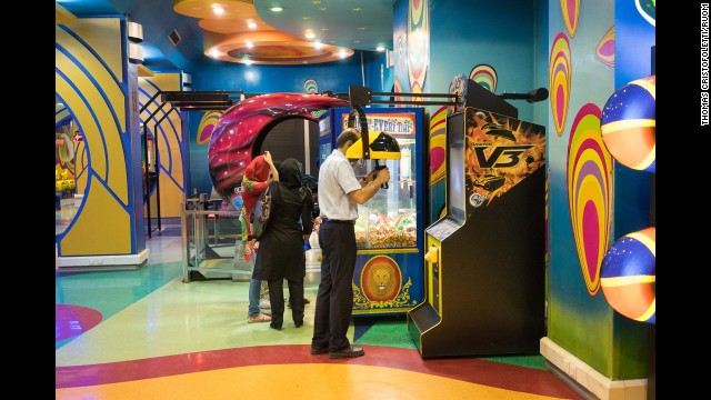 A man plays a video game in the arcade section of a Shiraz mall.