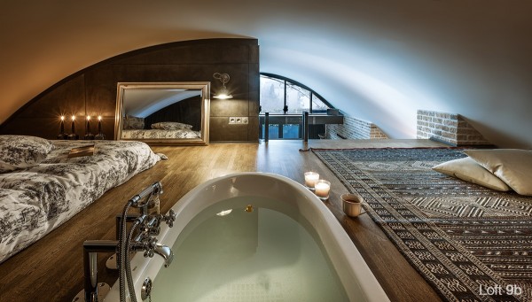 The second floor bedroom, up close to the curved ceiling, serves as a guest bedroom as well as a bathing area, with an in-floor bathtub.