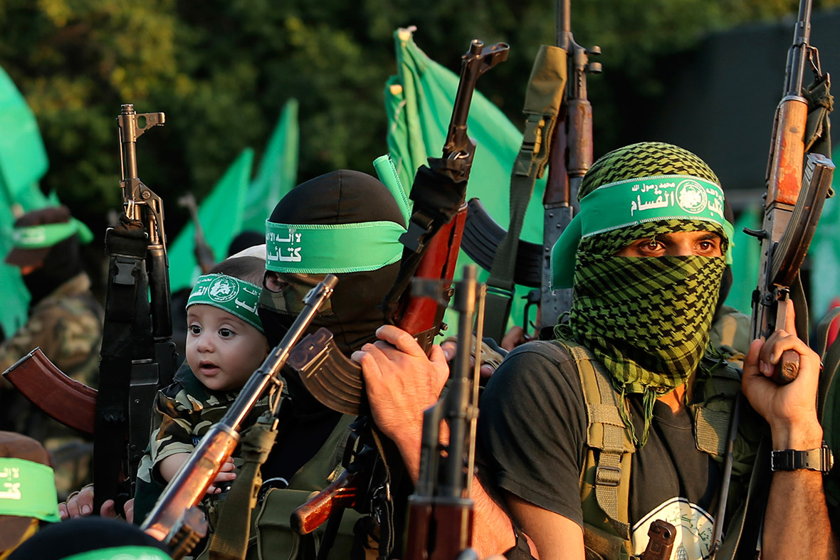 A militant holds a baby boy as Hamas celebrates 'a victory' over Israel, in Gaza City.