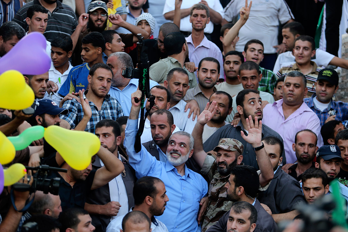 Ismail Haniyeh, Hamas leader, and disputed prime minister of Gaza, holds a gun during a rally in Gaza City as he appears for the first time since the start of the seven-week conflict.