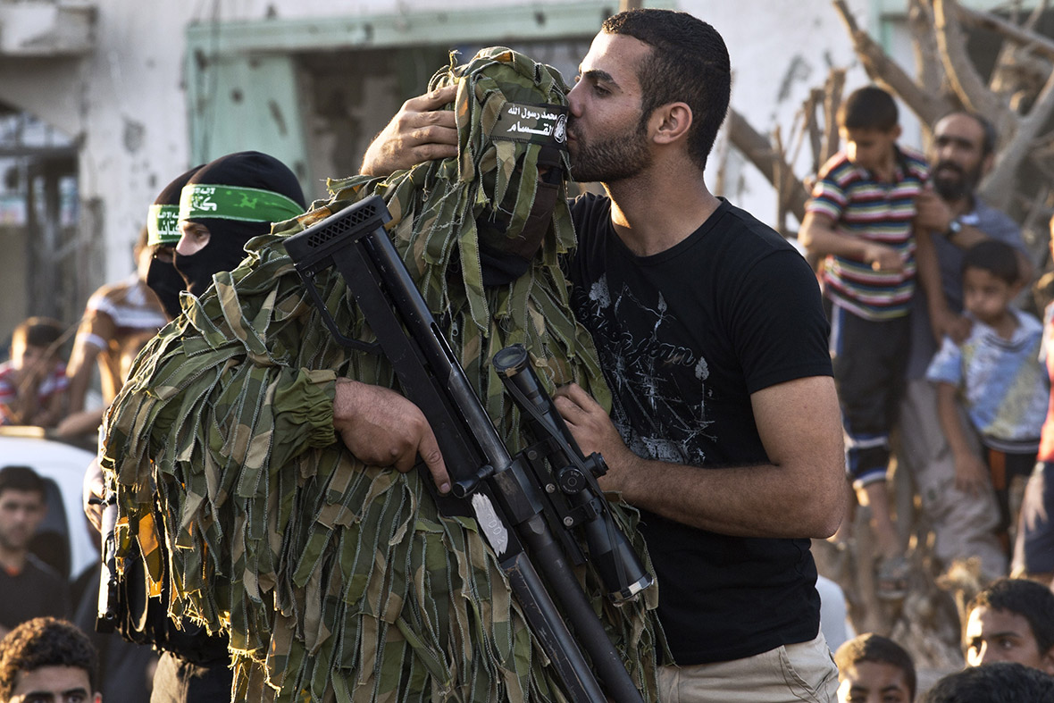 A Palestinian man kisses a Hamas sniper during a parade by militants in Shejaiya.