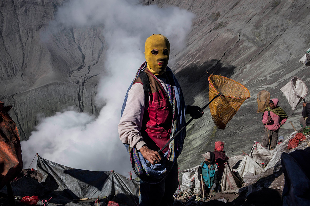 Villagers with nets prepare to catch offerings thrown by Hindu worshippers into the crater of Mount Bromo