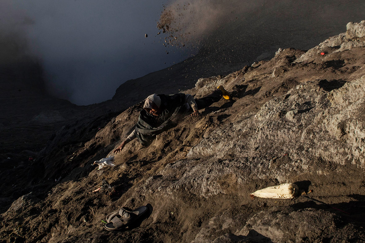 A villager tries to catch a chicken thrown by Hindu worshippers into the crater of Mount Bromo