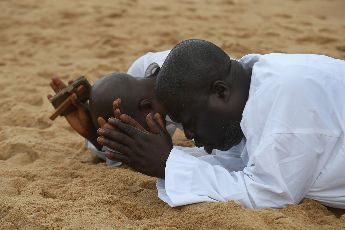Two men pray on the beach in Monrovia, calling for God to help Liberia during the current Ebola crisis