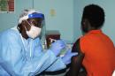 Health worker injects a woman with an Ebola vaccine during a trial in Monrovia