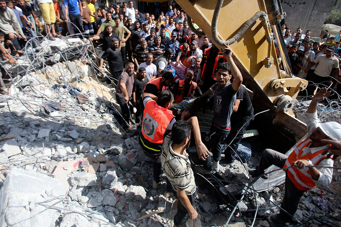 Palestinian rescue workers use an excavator to help remove the body of a man from under the rubble of a house in Rafah