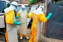 Medical staff clean their protection suits as part of the fight against the Ebola virus on March 8, 2015 at the Donka hospital in Conakry