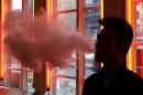 FILE - In this Feb. 20, 2014, File photo, a patron exhales vapor from an e-cigarette at the Henley Vaporium in New York. The first peek at a major study of how Americans smoke suggests many use combinations of products, and often e-cigarettes are part of the mix. It's a preliminary finding, but it highlights some key questions as health officials assess electronic cigarettes. (AP Photo/Frank Franklin II, File)