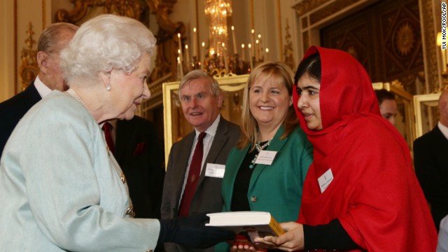 Malala gives a copy of her book to Britain's Queen Elizabeth II during a reception for youth, education and the commonwealth at Buckingham Palace in London on Friday, October 18.