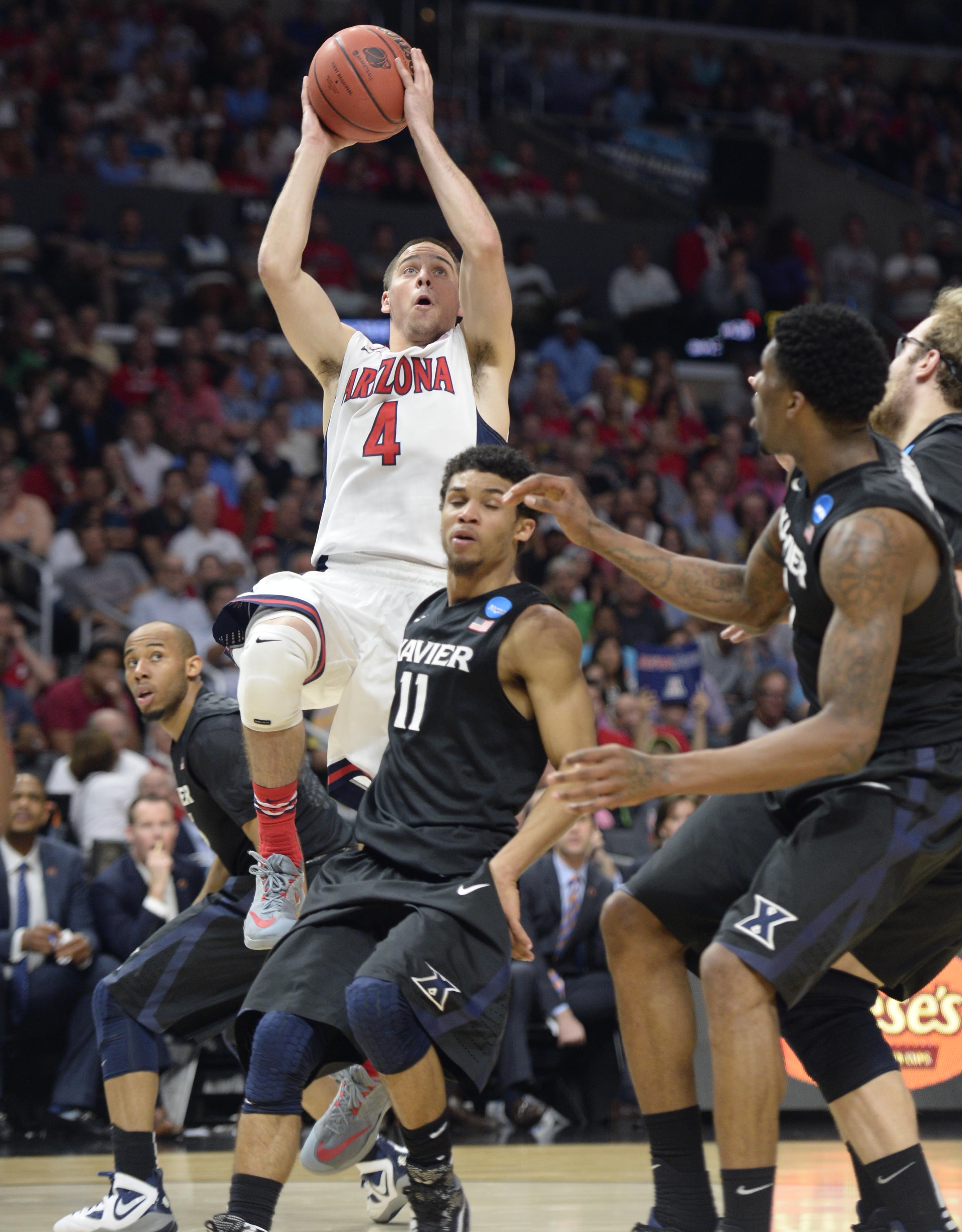 Mar 26, 2015; Los Angeles, CA, USA; Arizona Wildcats guard T.J. McConnell (4) moves to the basket against Xavier Musketeers guard Dee Davis (11) during the first half in the semifinals of the west regional of the 2015 NCAA Tournament at Staples Center. (Robert Hanashiro-USA TODAY Sports )