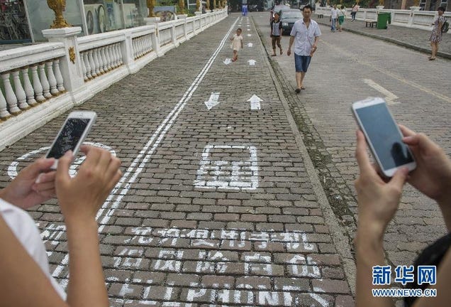 Smartphone Sidewalks Pop Up on a Busy Street in China