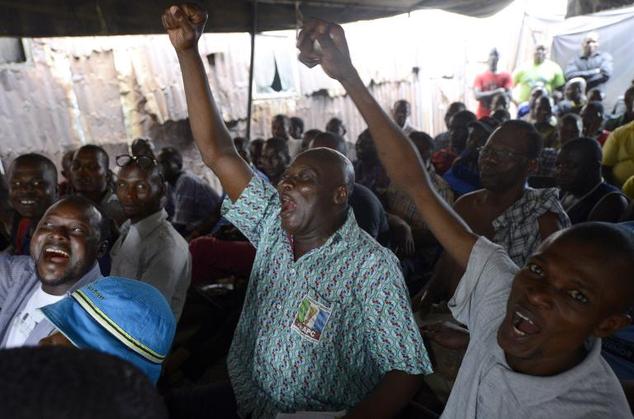 People react as partial results of the Nigerian presidential elections are released by the Independent National Electoral Commission indicating the main oppo...