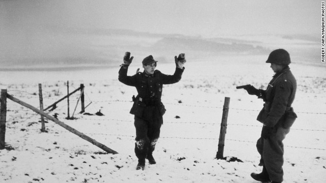 Mid-December 1944 saw the beginning of the six-week Battle of the Bulge on Europe's Western Front. War photographer Robert Capa immersed himself with Allied troops. Here, an American soldier points a gun at a German prisoner of war.