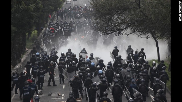 Riot police march to confront protesters near the airport in Mexico City on Thursday, November 20. Tens of thousands of demonstrators marched in Mexico's capital city after tensions have mounted over the disappearance of 43 college students in September.