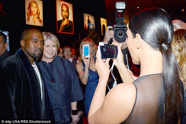 In-demand: The 53-year-old also cuddled up to Kanye West for a snapshot as the stars mingled inside the party