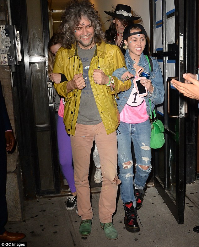 Party on: Miley Cyrus flashed a big smile as she headed out of a New York bar with pals on Thursday night