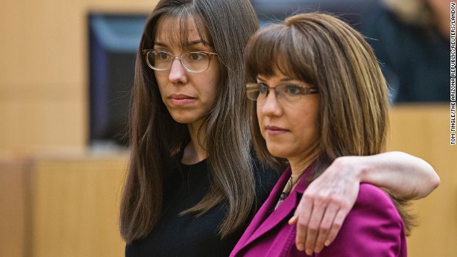Arias puts her arm around defense attorney Jennifer Willmott after being asked to demonstrate how she had her arm around her sister in a photograph that had been admitted into evidence on March 4.