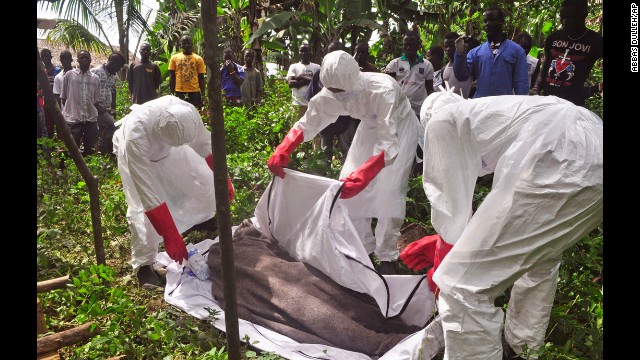 Health workers in Monrovia, Liberia, cover the body of a man suspected of dying from the Ebola virus on Friday, October 31. Health officials say the Ebola outbreak in West Africa is the deadliest ever. More than 4,900 people have died there, according to the World Health Organization.