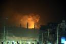 Columnas de humo y fuego se alzan sobre edificios durante un ataque aéreo supuestamente de la alianza liderada por Arabia Saudí contra un deposito de armas ayer en Sana (Yemen). EFE