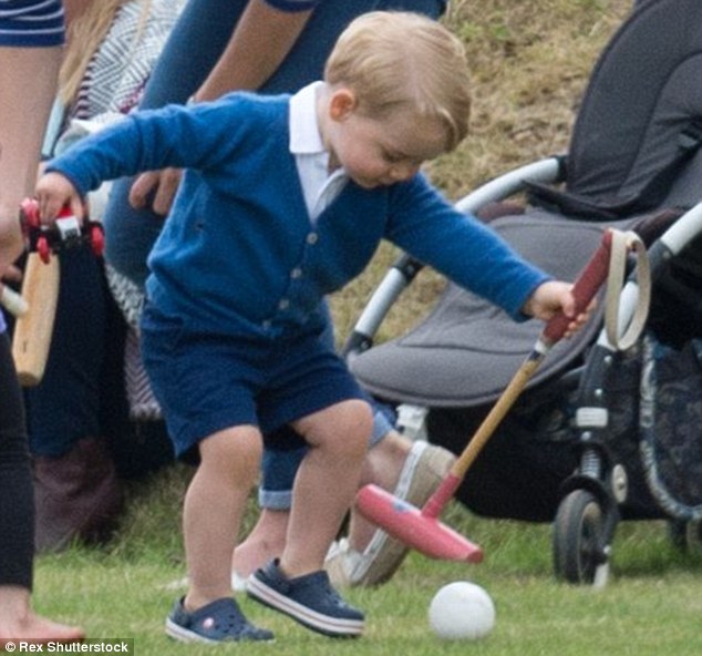 That's my boy: Prince George plays 'polo' left-handed, suggesting he has inherited his father's left hand