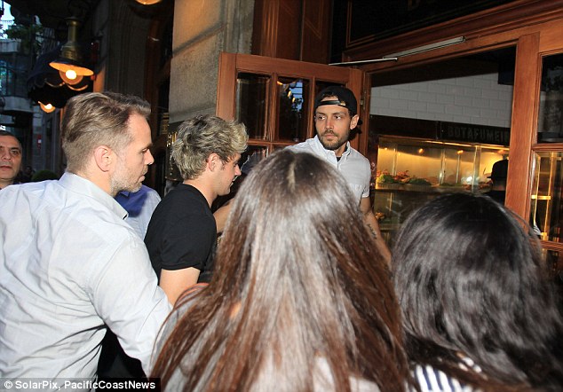 Making a swift entrance: The Irish pop star was accompanied by his minder as he rushed into the restaurant