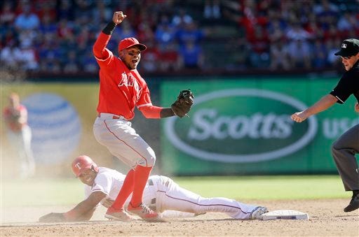Texas Rangers' Elvis Andrus, bottom, lays on the ground as Los Angeles Angels shortstop Erick Aybar, top, reacts after the out call on the steal attempt at second base by umpire Quinn Wolcott ending a baseball game in Arlington, Texas, Saturday, Oct. 3, 2015. The Angels won 11-10. (AP Photo/LM Otero)