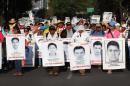 Ciudadanos mexicanos sostienen carteles con fotografías de los 43 estudiantes desaparecidos durante una manifestación en calles de Ciudad de México (México). EFE