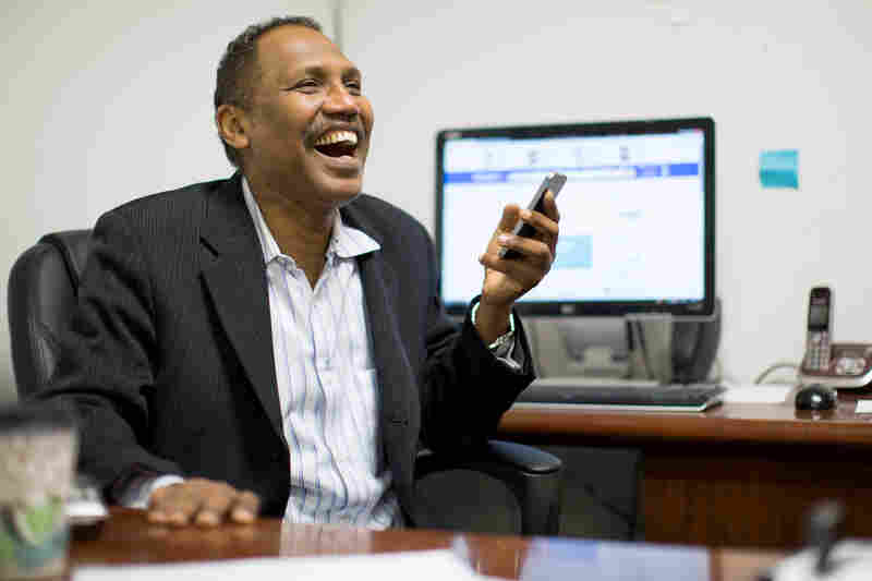Omar Shekhey has a laugh while fielding questions and phone calls at the Somali American Community Center in Clarkston, Ga. Shekhey, who runs the nonprofit group, has been helping Clarkston's refugee community for several years though the center and an after-school program.