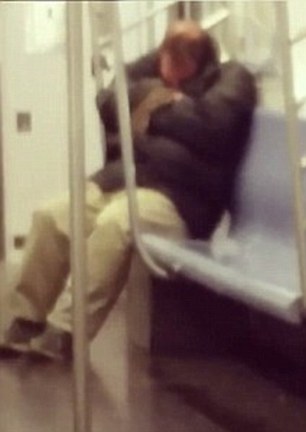 An unsuspecting man is sleeping on the tube while a rat sniffs its way around him