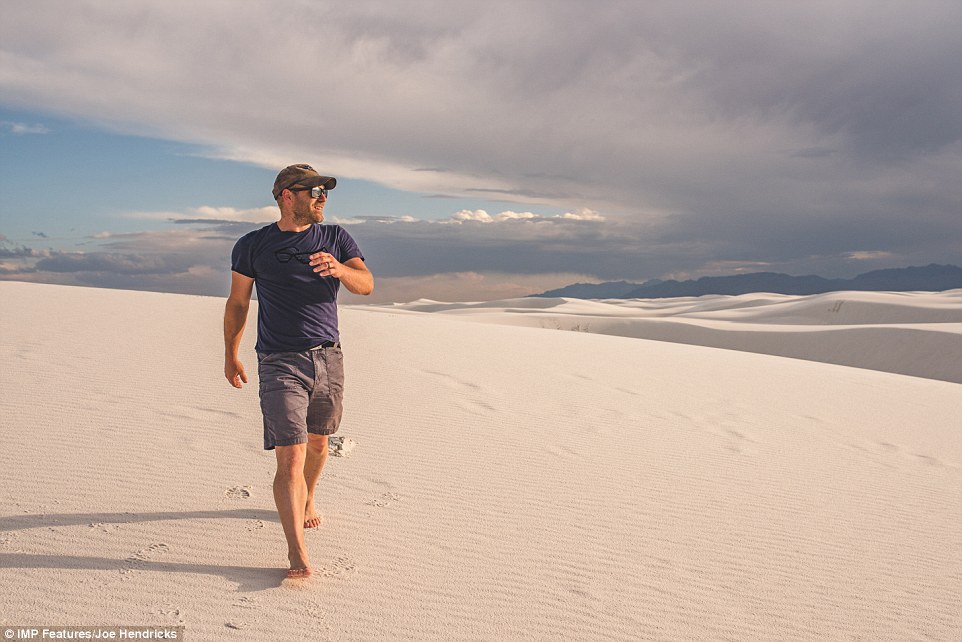 Joe Hendricks is pictured smiling as he walks along the untouched sand at the White Sands National Monument in New Mexico