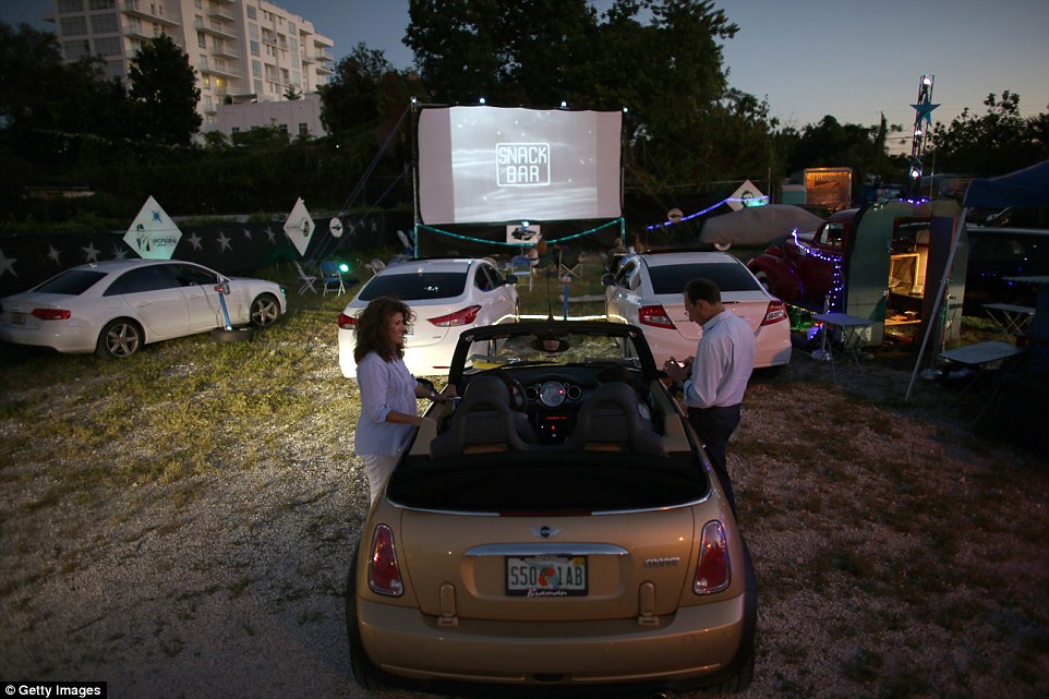Viewers relax in their cars while watching films such as The Wizard of Oz at the Blue Starlite Mini Urban Drive-In in Miami and Austin