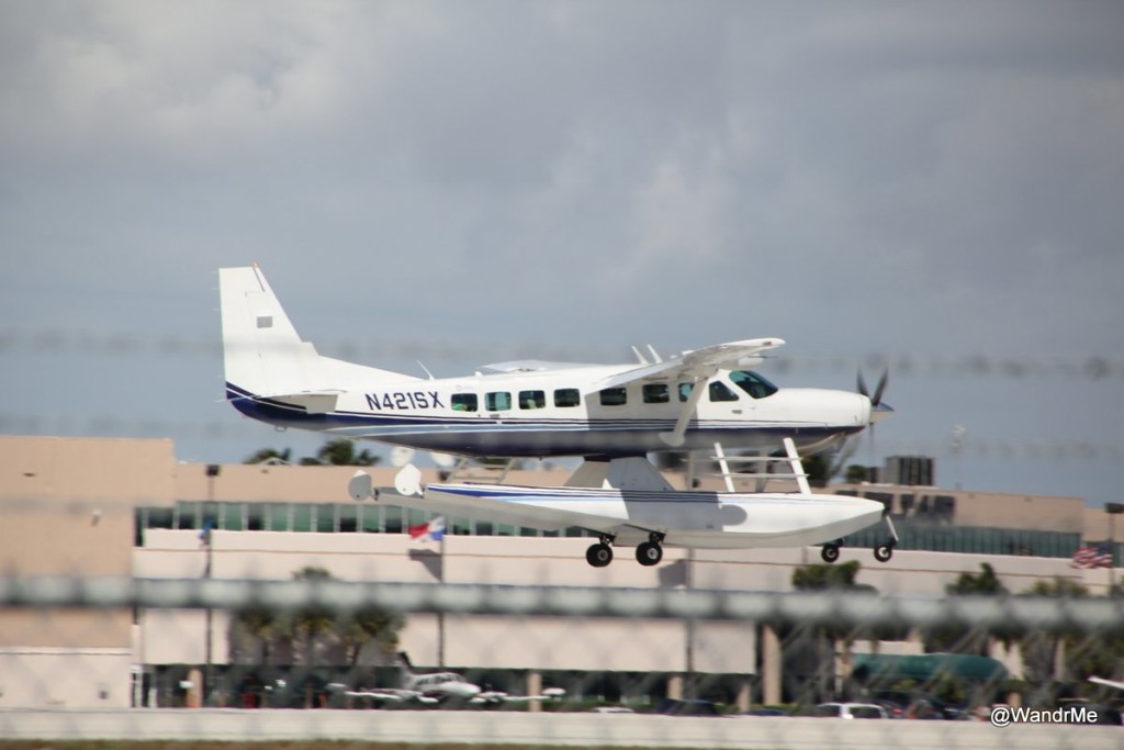 A Cessna 208 with pontoons landing at FLL