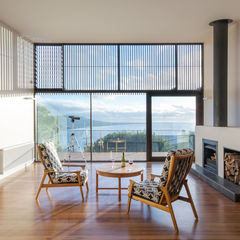 Living room with ocean views in Australian beach home by OLA Studio