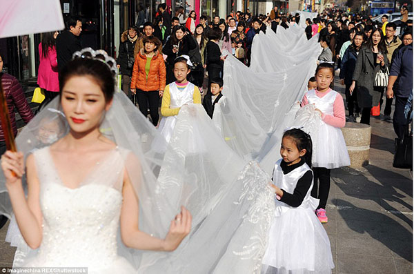 عارضة أزياء تجوب شوارع الصين بفستان يبلغ طوله 100 متر! 