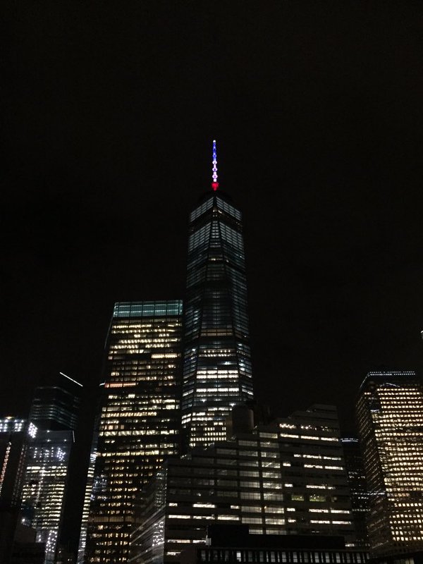 The antenna of the World Trade Center is red white blue tonight in solidarity