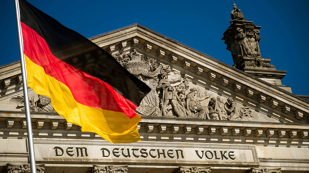 Die Deutsche Fahne weht unter einem blauem Himmel bei Sonnenschein vor dem Reichstag in Berlin. | Bildquelle: dpa