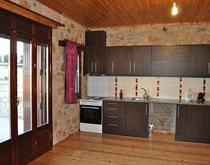 A modern kitchen with pretty stone walls awaits inside