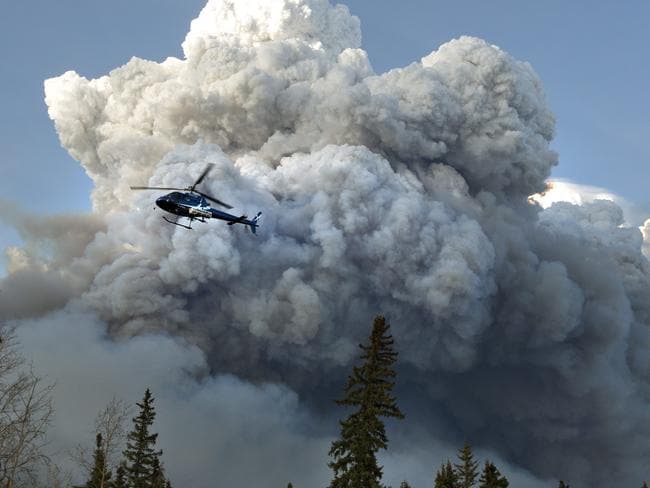 A helicopter flies past a wildfire in Fort McMurray, Alberta. Picture: Jason Franson /The Canadian Press via A