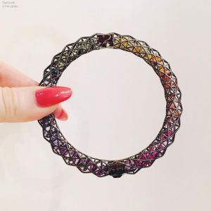 A crazy awesome @rouleandcompany shaker bangle with caged rainbow gemstones