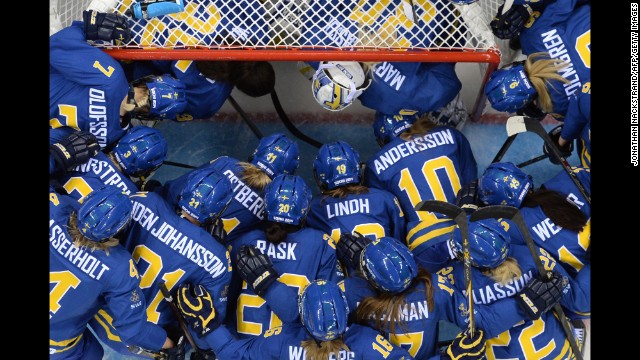 Sweden's players gather at the net before the women's Group B hockey match between Sweden and Germany on February 11.