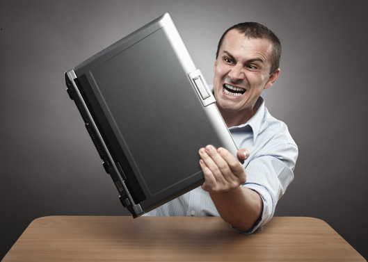 Angry businessman smashing his laptop