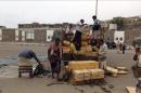 Milicianos leales al presidente Abdo Rabu Mansur Hadi recogen cajas llenas de armas supuestamente entregadas por la coalición árabe encabezada por Arabia Saudí que lucha en el Yemen contra los combatientes hutíes, en el puerto de Adén, Yemen. EFE