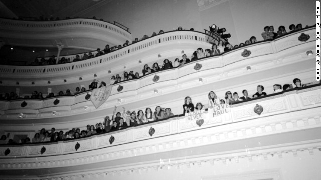Fans cheer for The Beatles and hold signs of encouragement during the band's concert at Carnegie Hall on February 12, 1964, in New York.
