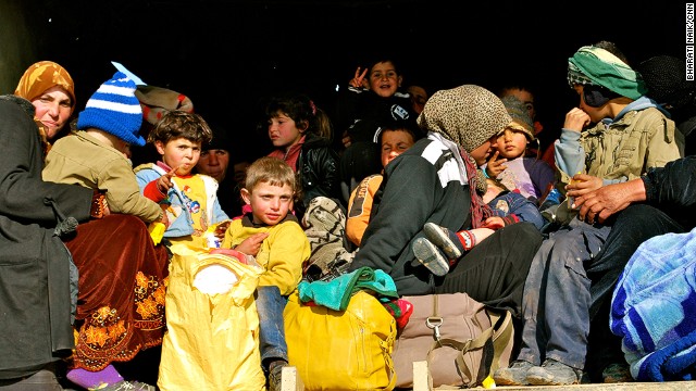 Exhausted refugees pile into a truck for the half hour trip to the border camp, where they will be given food and water and processed.