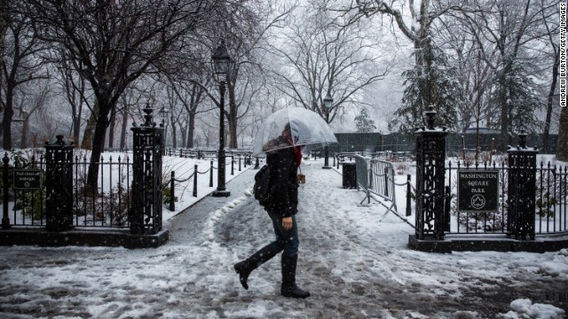 A woman walks through Washington Square Park as snow falls in New York on February 3.